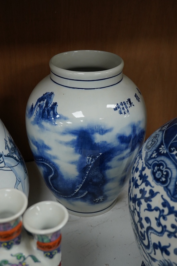 Three blue and white Chinese porcelain vases, a similar jar and cover, plus three stacking jars and covers on stand, a large dragon designed charger on stand and a similar decorated vase, charger 39cm diameter (7). Condi